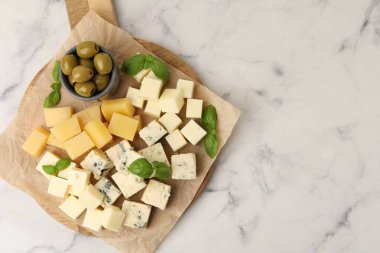 Farklı peynir, zeytin ve fesleğen içeren servis masası, üst manzara. Metin için boşluk