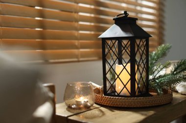 Noel feneri, yanan mumlar ve kapalı bir bankta köknar dalları, yakın çekim. Sıcak atmosfer