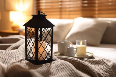 Güzel bir Noel feneri, yanan mumlar ve sıcak bir bardak içecekle birlikte.