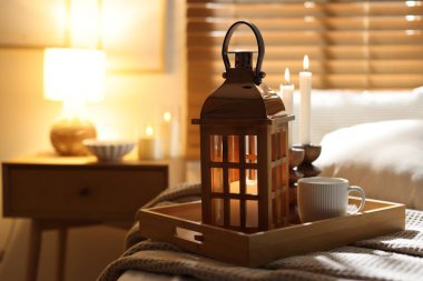 Güzel bir Noel feneri, yanan mumlar ve sıcak bir bardak içecekle kapalı bir yerde, yakın plan. Metin için boşluk