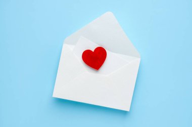 Sevgililer Günün kutlu olsun. Tebrik kartı ve açık mavi arka planda dekoratif kalp ile zarf, üst görünüm