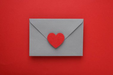 Sevgililer Günün kutlu olsun. Tebrik kartı ve kırmızı arka planda dekoratif kalp ile zarf, üst görünüm