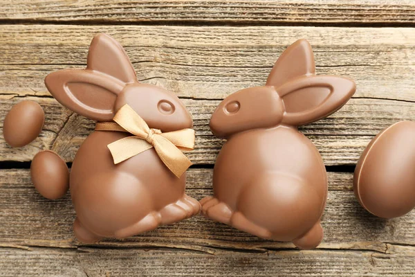 Çikolatalı Paskalya tavşanları ve yumurtalar ahşap masada, düz yatıyordu.