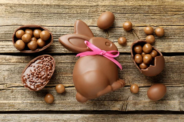 Çikolatalı Paskalya tavşanı ve yumurtalar ahşap masada, düz yatıyordu.