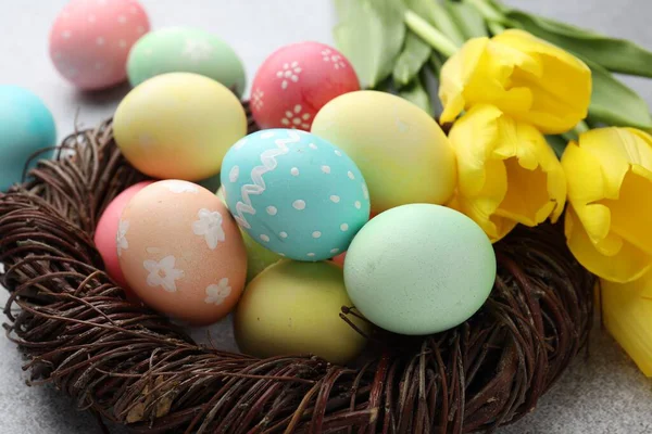 Yuvada boyanmış Paskalya yumurtaları ve masada güzel laleler, yakın plan.
