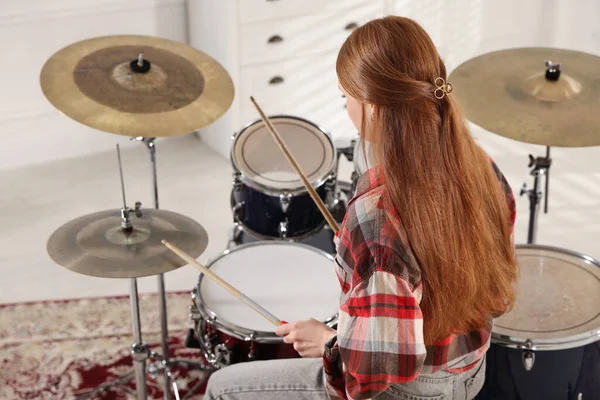 Bagetli genç kız davul çalmayı içeride, arka planda öğreniyor.