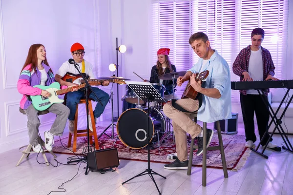 Gençlik bandosu içeride müzik öğretmeniyle performans çalışması yapıyor.