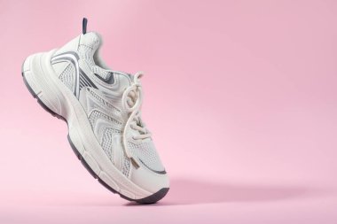One stylish sneaker on pink background, closeup. Space for text