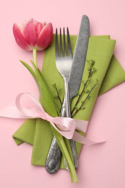 Paskalya kutlaması. Pembe arka planda çiçek dekoru olan şenlik masası, üst görünüm