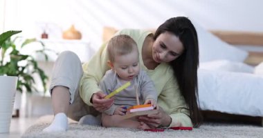 Anne ve bebeği evde oyuncak piramitlerle oynuyorlar.