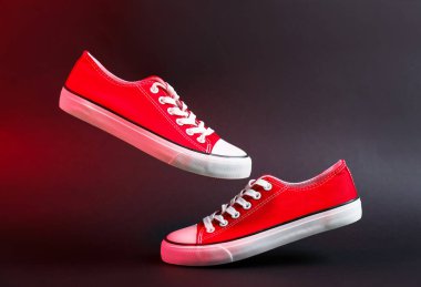 Siyah arka planda bir çift renkli spor ayakkabısı.