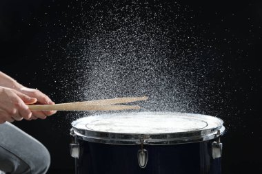 Siyah arkaplanda davul çalan bagetli adam, yakın plan