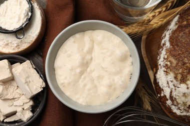 Hamur mayası ve malzemeler ahşap masada, düz yerde.