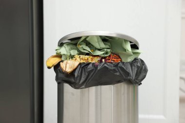 Mutfakta çöp dolu metal çöp kutusu, yakın plan.