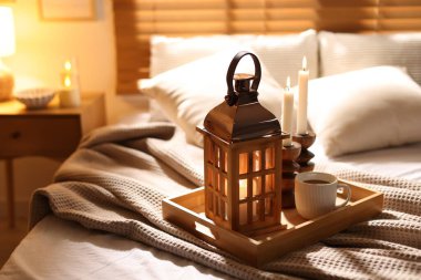 Güzel bir Noel feneri, yanan mumlar ve sıcak bir bardak içecekle kapalı bir yerde, yakın plan. Metin için boşluk