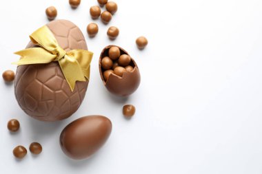 Beyaz arka planda çikolatalı Paskalya yumurtaları ve şekerler. Metin için boşluk