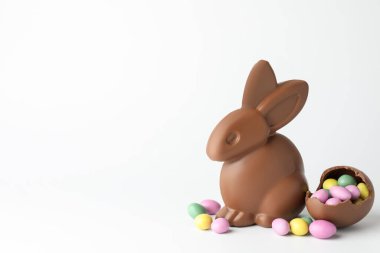 Çikolatalı Paskalya tavşanı ve beyaz arka planda şekerli yumurtalar. Metin için boşluk