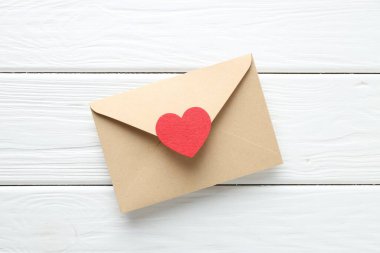 Valentine's day greeting card. Envelope with decorative heart on white wooden table, top view