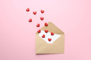 Sevgililer Günün kutlu olsun. Tebrik kartı ve pembe arka planda dekoratif kalpler içeren zarf, düz uzanma