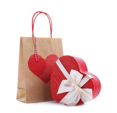 İçinde kalp şeklinde hediye paketi olan kağıt torba beyaza izole edilmiş. Sevgililer Günü