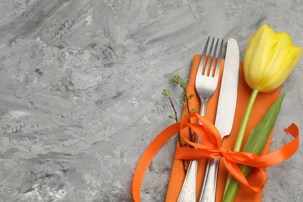 Paskalya sofrası. Gri arka planda lalesi olan güzel gümüş takımlar, üst manzara. Metin için boşluk