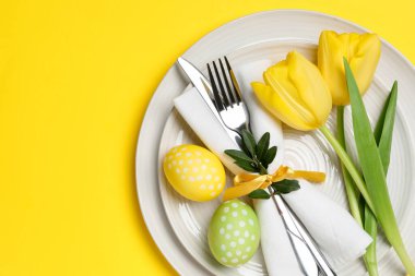 Paskalya kutlaması. Lale çiçekleri ve sarı arka planda boyanmış yumurtalar, üst manzara. Metin için boşluk