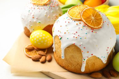 Lezzetli Paskalya pastaları ve beyaz masaya boyanmış yumurtalar, yakın plan.