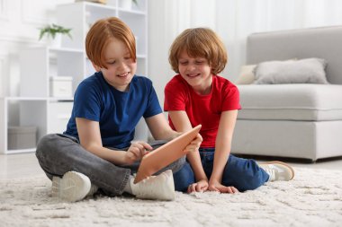 Evde tabletleri olan sevimli kardeşler.