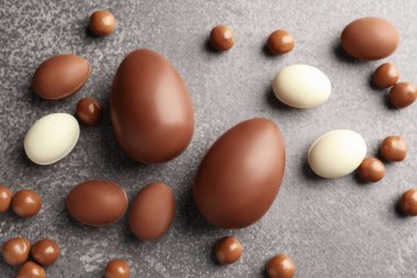 Paskalya kutlaması. Gri desenli masa üzerinde bir sürü çikolatalı yumurta ve kuru üzüm.