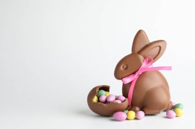 Çikolatalı Paskalya tavşanı ve beyaz arka planda şekerli yumurtalar. Metin için boşluk
