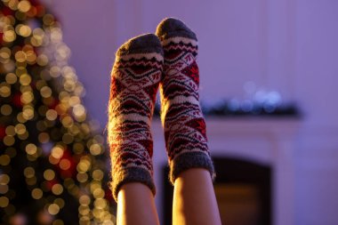 Evde Noel ağacına karşı rahat çorap giyen bir kadın, yakın plan.
