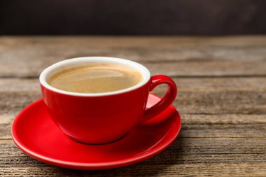 Ahşap masanın üzerinde aromatik kahve olan bir fincan, yakın plan. Metin için boşluk