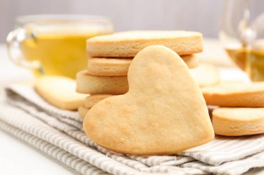 Lezzetli kalp şeklinde tereyağlı kurabiyeler masada, yakın plan.