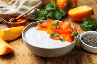 Hurmalı lezzetli chia pudingi ve ahşap masada servis edilen nane şekeri.