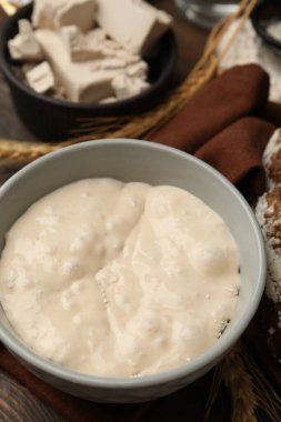 Hamur mayası ve malzemeler ahşap masada, yakın plan.