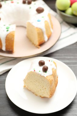 Paskalya pastasını kes ve ahşap masaya yumurta boya, yakın plan.