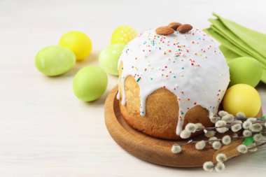 Lezzetli Paskalya pastası, boyanmış yumurtalar ve söğüt dalları beyaz ahşap masa üzerinde, yakın plan. Metin için boşluk