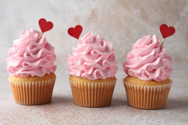 Sevgililer Günün kutlu olsun. Gri masadaki kırmızı kalpli kapkekler, yakın plan.