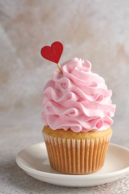 Sevgililer Günün kutlu olsun. Gri masadaki kırmızı kalpli tatlı kek, yakın plan.