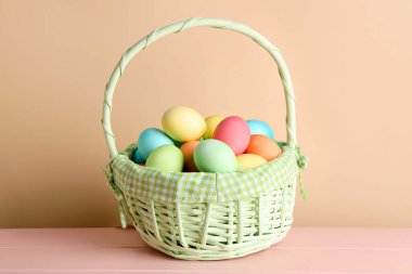 Güzel Paskalya yumurtaları pembe ahşap masanın üzerinde bej arka planda