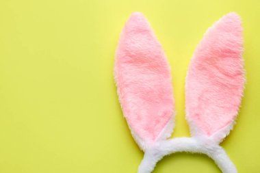 Mutlu Paskalyalar. Açık yeşil arka planda tavşan kulaklı şirin saç bandı, üst manzara. Metin için boşluk