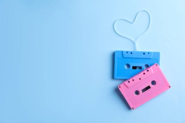 Müzik kasetleri ve açık mavi arka planda bant ile yapılmış kalp, üst manzara. Metin için boşluk