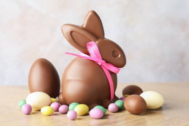Çikolatalı Paskalya tavşanı ve yumurtalar açık gri arka planda, yakın plan.