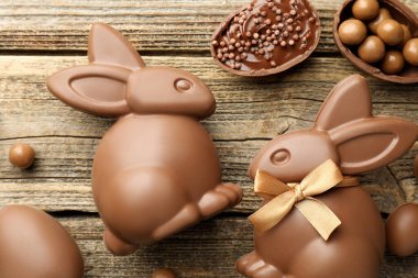 Çikolatalı Paskalya tavşanları ve yumurtalar ahşap masada, düz yatıyordu.