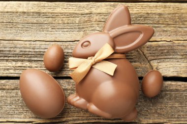 Çikolatalı Paskalya tavşanı ve yumurtalar ahşap masada, düz yatıyordu.