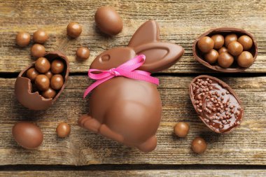 Çikolatalı Paskalya tavşanı ve yumurtalar ahşap masada, düz yatıyordu.