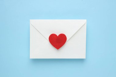 Sevgililer Günün kutlu olsun. Tebrik kartı ve açık mavi arka planda dekoratif kalp ile zarf, üst görünüm