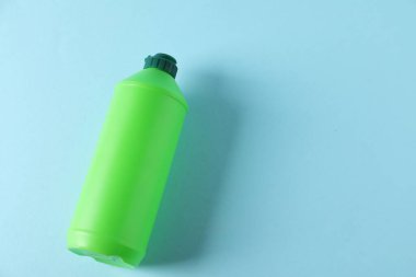 Plastik ambalaj. Deterjan şişesi açık mavi arka planda, yukarıda. Metin için boşluk
