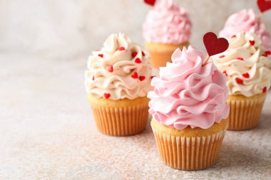 Sevgililer Günün kutlu olsun. Gri masada kırmızı kalpleri olan lezzetli kekler, yakın plan. Metin için boşluk