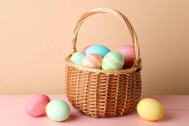 Güzel Paskalya yumurtaları pembe ahşap masanın üzerinde bej arka planda